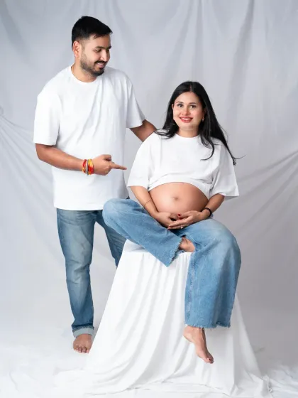 Maternity photos can be relaxed, modern, and fun. We love this casual couple's shot with matching white t-shirts and jeans, celebrating the baby bump with pure joy and authenticity.