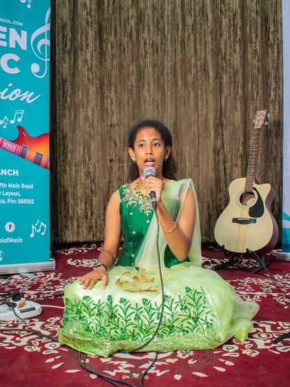 A student performs a Carnatic song at our HSR branch open mic. The setting is designed to be encouraging for students to showcase their progress.