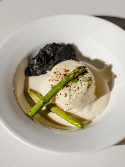 Another example of a sophisticated small plate, featuring a poached egg, asparagus, and a savory crumble. This style of service allows guests to mingle while enjoying high-quality, chef-plated dishes.
