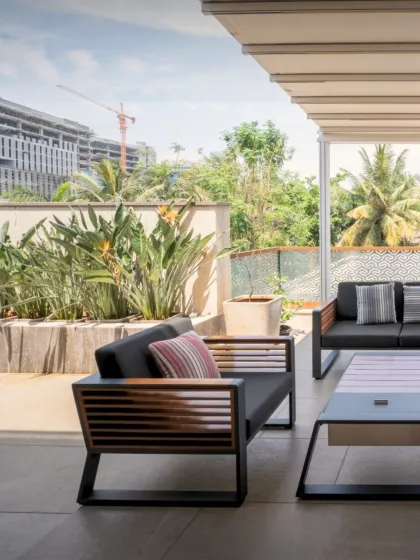 Another view of the outdoor lounge, highlighting the custom-designed furniture with slatted wood details that echo architectural elements. The space is designed for comfort and style in an urban setting.