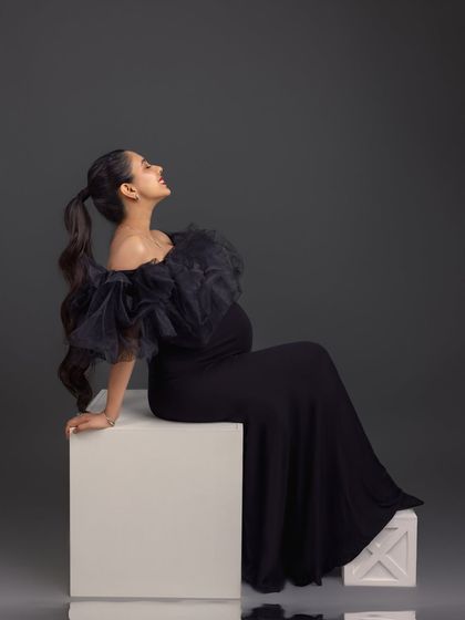 A joyful and expressive pose. This seated portrait captures a moment of pure happiness and anticipation.