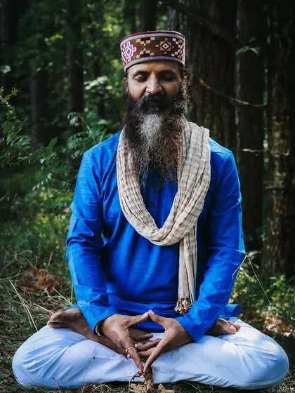 In the quiet of the forest, I find my deepest connection. Here, I am seated in meditation, a practice that is the foundation of all my teachings. It is in these moments of silence that we can truly listen to our inner voice.