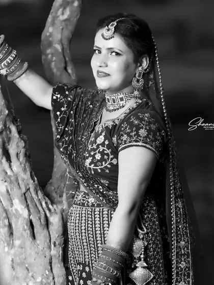 A timeless black and white bridal portrait. Stripping away the color allows the focus to fall on the bride's expression and the beautiful textures of her traditional wedding dress and the natural surroundings.