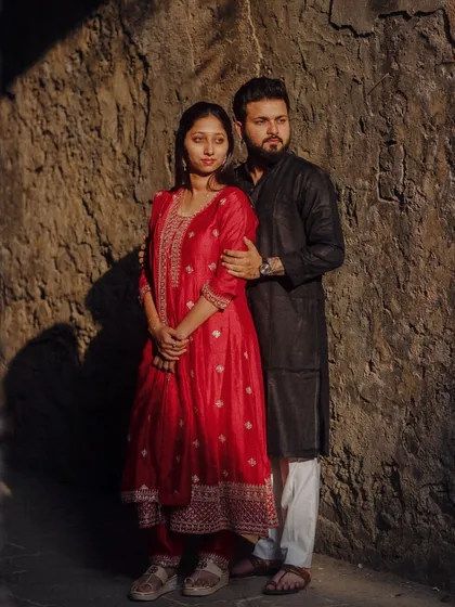 A classic portrait against a textured stone wall. The play of light and shadow adds depth and drama to this pre-wedding shot.