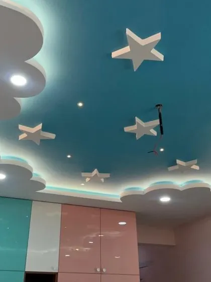 A full view of the kids' bedroom, showcasing how the colorful wardrobe and the imaginative false ceiling come together to create a cohesive and joyful space.