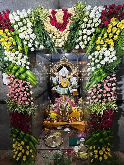 My work includes detailed floral adornment for temple deities. Here, a floral arch made of roses and chrysanthemums frames the idol, enhancing the sacred atmosphere.
