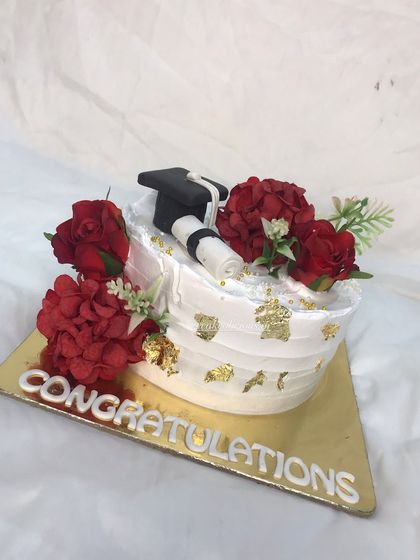A closer look at the details on the white whipped cream graduation cake.