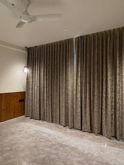 This room is ready for handover, featuring wood wainscoting and full-length curtains that create a cozy and elegant atmosphere.