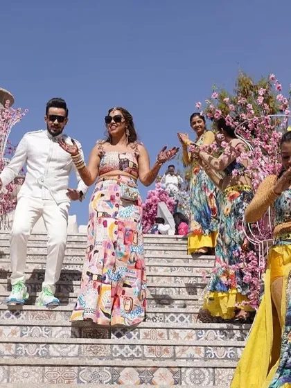 The couple makes their way down the stairs in our Greece-themed carnival setup. Every detail, from the floral decor to the dancers' costumes, was planned to transport guests to another world.