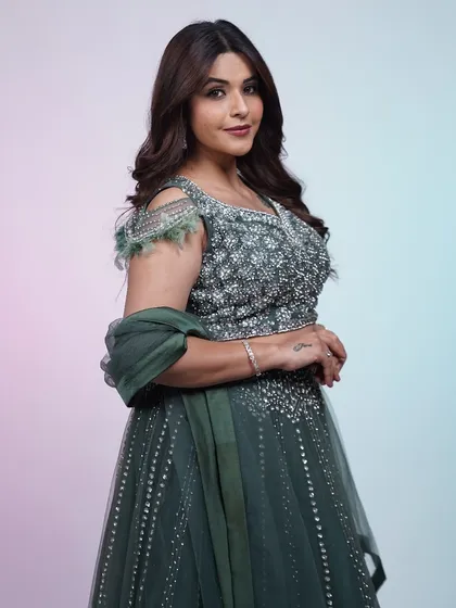 A full-length shot of the dark green lehenga, showing how the sequin work catches the light. It's a perfect choice for an evening reception.