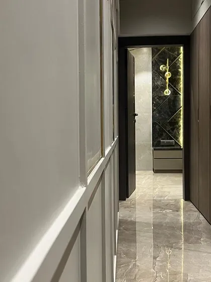 A view down a corridor in the Juhu apartment, where I used reflective marble flooring and contrasting wall treatments to create a sense of length and luxury. The lighting is designed to highlight the different materials.