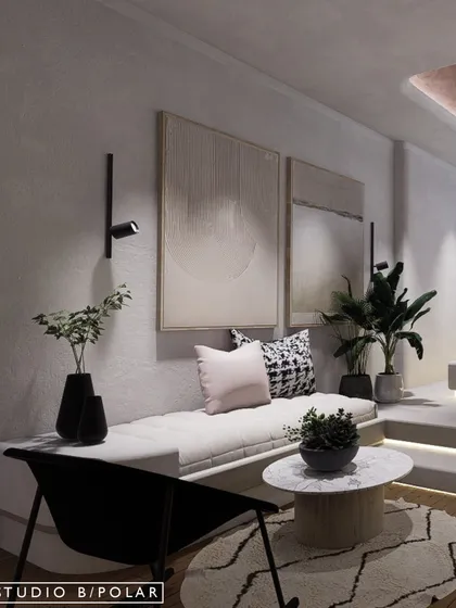 The lower level of the room serves as a cozy seating area, with a comfortable daybed and a small coffee table. The space feels tranquil, grounded, and full of understated beauty.