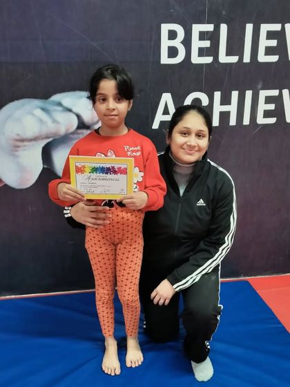 This student proudly holds her certificate, a reward for her dedication.