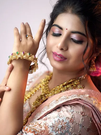 A close-up on the hands and wrists, highlighting the intricate design of our traditional bangles that perfectly match the necklace set.