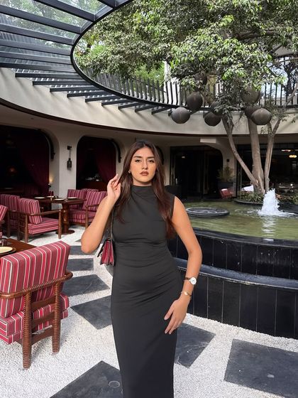 A close-up of the black dress, showing the high-neck detail.