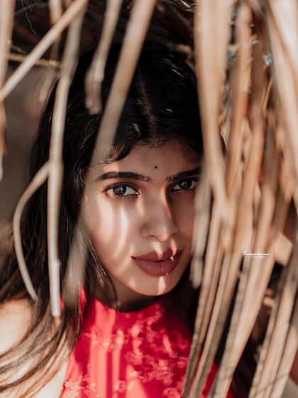 An intimate and engaging portrait, peeking through the leaves. This composition creates a sense of mystery and draws the viewer in.