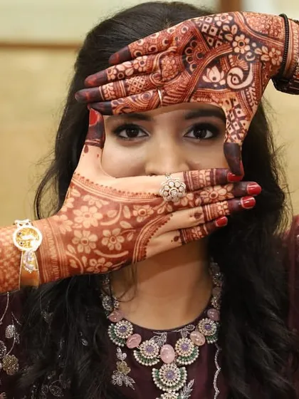 Framing her face with her beautiful mehendi. The soft glam makeup, featuring defined eyes and a neutral lip, was the perfect choice for her engagement ceremony.