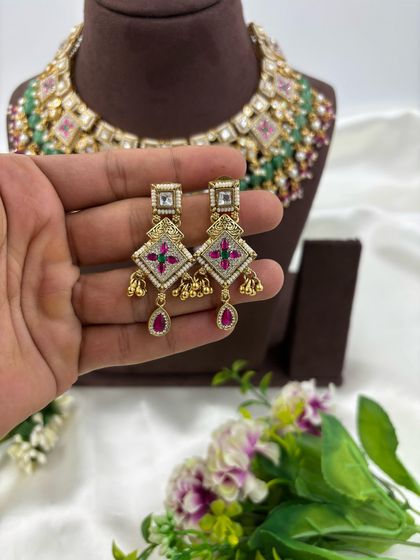 The Divya Premium Antique Gold Necklace set. This piece features unique square motifs with Meenakari work, layered with green and ruby beads for a colorful yet traditional look.