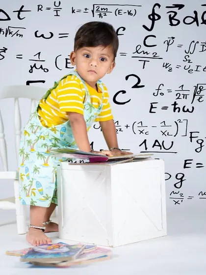 This little scholar is hard at work solving complex equations. The creative backdrop adds a fun and imaginative touch to the portrait.