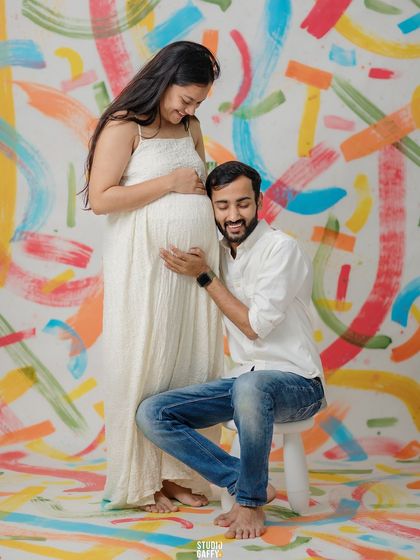 The father-to-be listens to the baby bump against our unique, custom-painted backdrop.