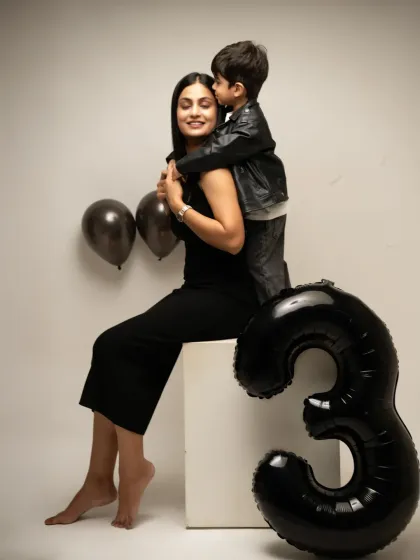A tender moment as a son gives his mom a kiss on the cheek during his third birthday session. These candid interactions create the most heartfelt memories.