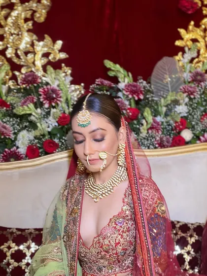 A serene, downward glance that beautifully displays the eyeshadow and glowing skin. This shot emphasizes the soft, romantic feel of the makeup, even within a grand and royal bridal look.