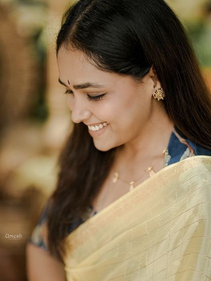 A close-up look at the delicate details. The simple jewelry and the elegant drape highlight the beauty of the saree without overpowering it.