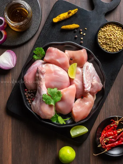 Raw chicken cuts marinated with Indian spices, ready for cooking, showcasing fresh ingredients for a meat delivery brand.