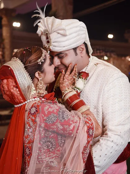 A tender moment between the bride and groom, as she gently touches his face.