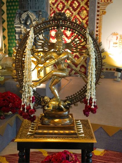 A classic brass Nataraja statue, adorned with fresh jasmine garlands, serves as a divine centerpiece. This element of traditional Indian decor adds a touch of grace and cultural richness to the wedding entrance.