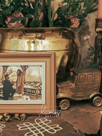 A close-up of a vintage car model and a framed proposal photo, part of a heritage-themed engagement decor.