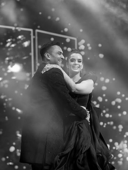 A black and white shot of the couple's first dance, filled with joy and surrounded by a magical sparkle effect.