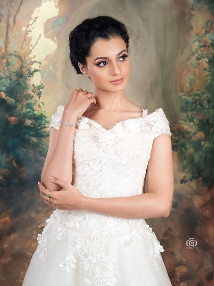 A close-up of the model in a white gown, set against a painted, classical-style backdrop. This creates a fine art feel, blending photography with the aesthetics of classical painting.