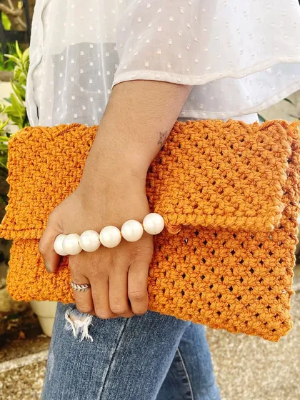 Style meets craftsmanship in this macramé clutch bag. I designed it to be a versatile accessory, perfect for both casual outings and special occasions. The intricate knotting is paired with an elegant pearl handle, creating a statement piece that is both beautiful and functional.