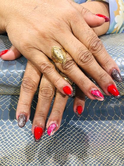 Another view of the red and glitter set, highlighting the delicate pink marble accent nail.