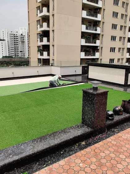 A member of our team carefully laying down the artificial turf. Precision is important to ensure there are no visible seams and the finish is perfectly flat.