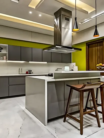 An island can be the centerpiece of your kitchen. Here, I used a sleek grey and white palette with a pop of chartreuse green on the accent wall, creating a dynamic and modern space perfect for both cooking and socializing.