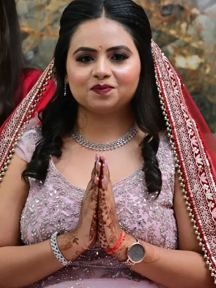 The bride with her hands in a 'namaste' pose, her beautiful smile and makeup welcoming guests to her engagement.