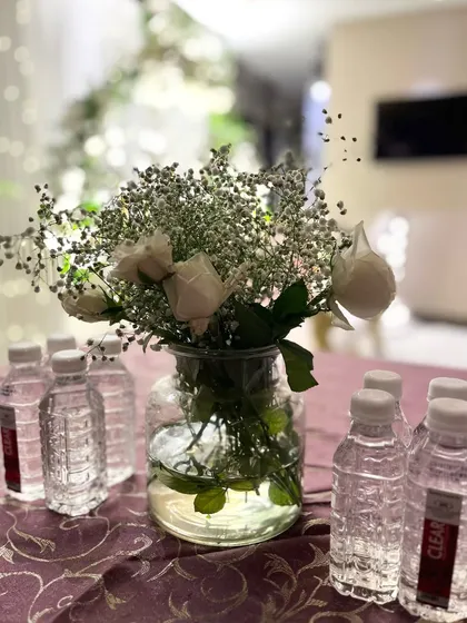 Another simple yet elegant centerpiece with white roses and baby's breath, perfect for creating a soft, romantic mood.