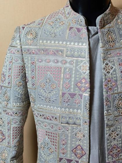 A detailed view of the chest and shoulder of the pastel sherwani. The combination of different embroidery techniques and colors creates a tapestry of incredible richness and artistry.