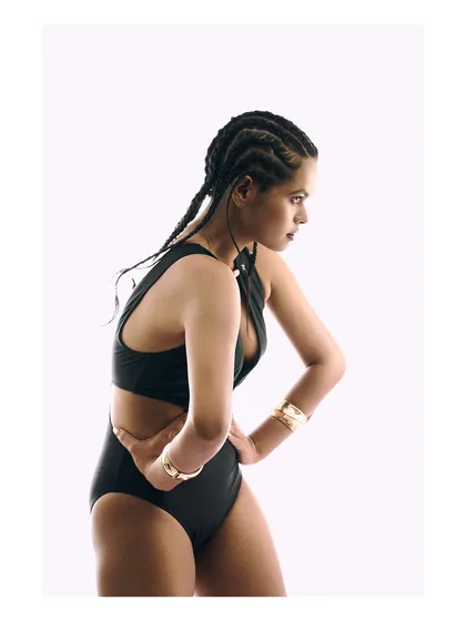 A different pose from the same high-key series, this image provides another angle of the swimsuit and gold bracelets. The clean, minimalist style is versatile and effective for lookbooks and online stores that want a modern feel.