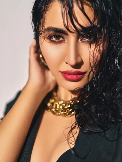 Bold and beautiful. This look on Khatija Iqbal features a wet-look hairstyle, a vibrant red lip, and a smokey eye, creating a sizzling and high-fashion statement.