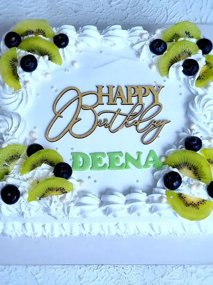 A top-down view of the Tres Leches cake, showing the arrangement of kiwi and blueberries.