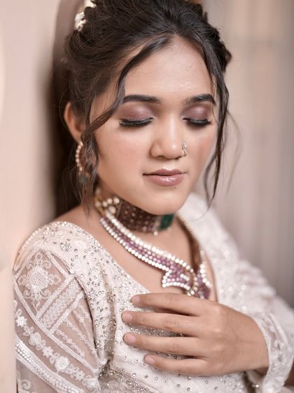 A close-up showing the soft makeup and the details of the hairstyle. The loose strands around the face add a touch of modern romance.