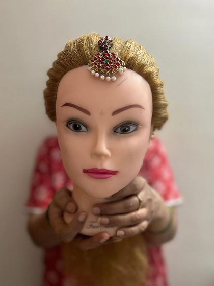 Another example of practicing with a traditional maang tika. My hands-on approach ensures students feel confident securing all types of bridal jewelry.