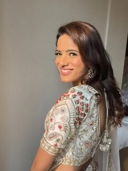 The happy client with her soft curls, showing how this hairstyle beautifully frames the face and complements her embroidered blouse.