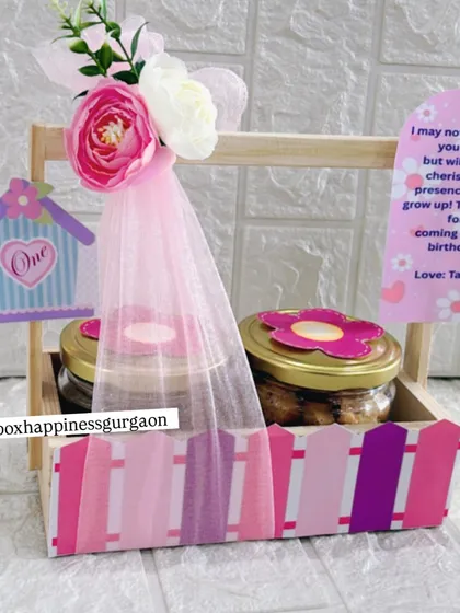 This image highlights the personalized thank you card and the charming details of the pink-themed first birthday favor.