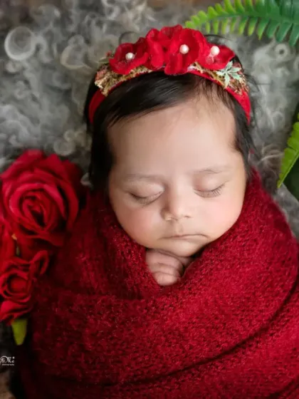 A close-up on this sleeping beauty's face, framed by red roses and a delicate headband. These are the details you'll want to remember forever.