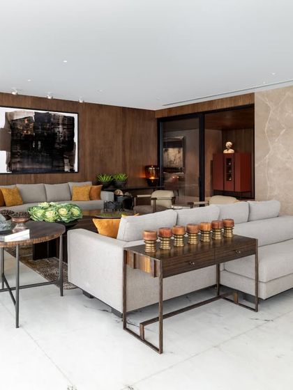 In this Camellias apartment, the living room is a study in layered textures and curated art. The custom ribbon veneer wall provides a warm, sculptural backdrop, while bespoke sofas and a Gopi Gajwani painting create a space that feels both sophisticated and deeply personal.