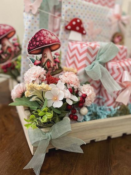 A close-up of the fairy garden details in the six-month hamper, showing the faux florals, mushroom cutouts, and delicate ribbons that bring the theme to life.